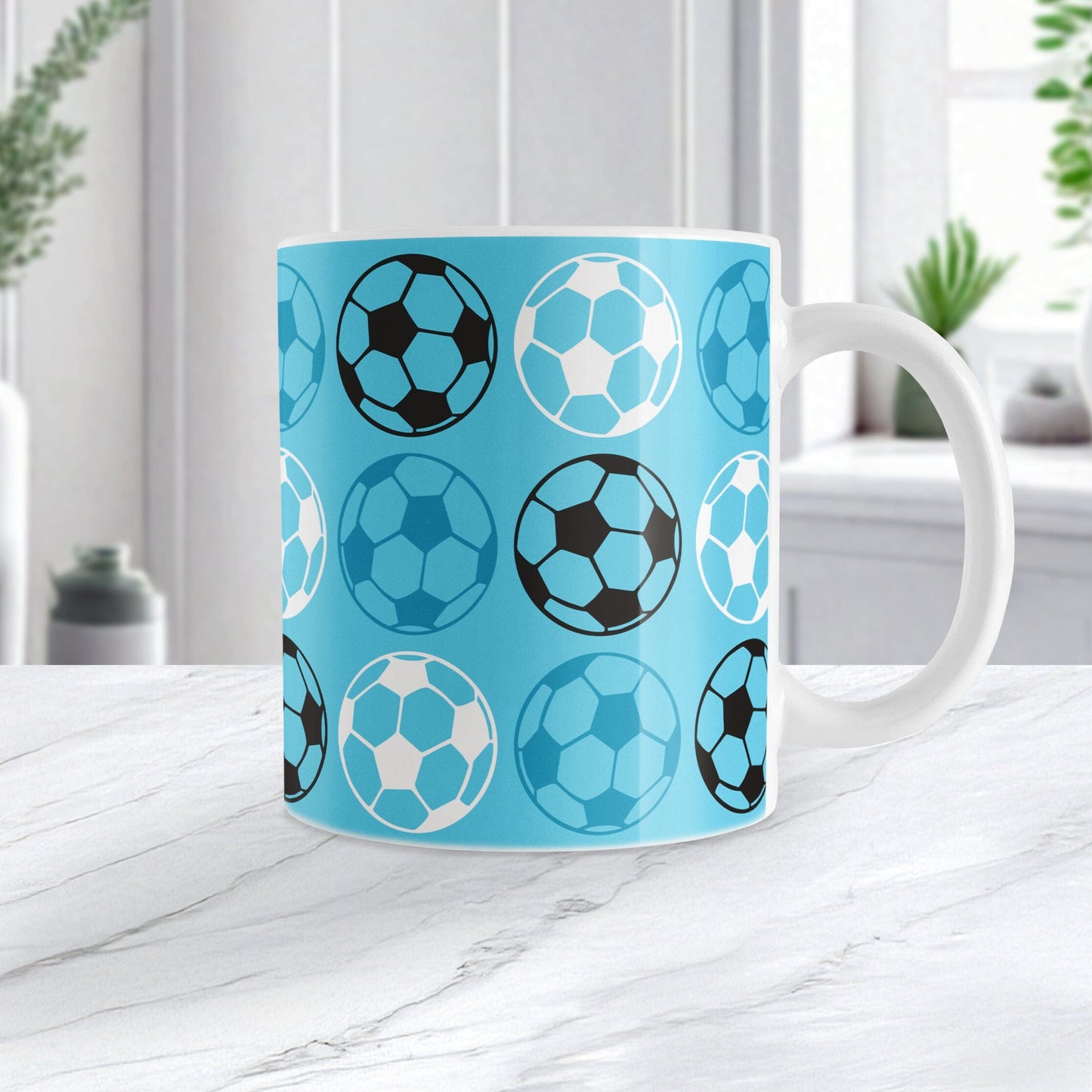 An 11oz white mug with a blue soccer pattern, sitting on a marble tabletop
