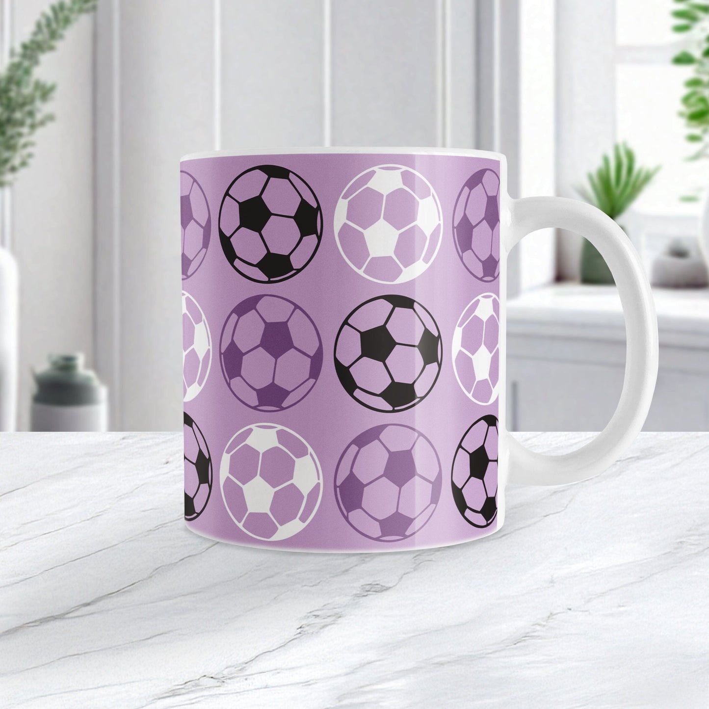 An 11oz white mug with a purple soccer ball pattern, setting on a marble tabletop