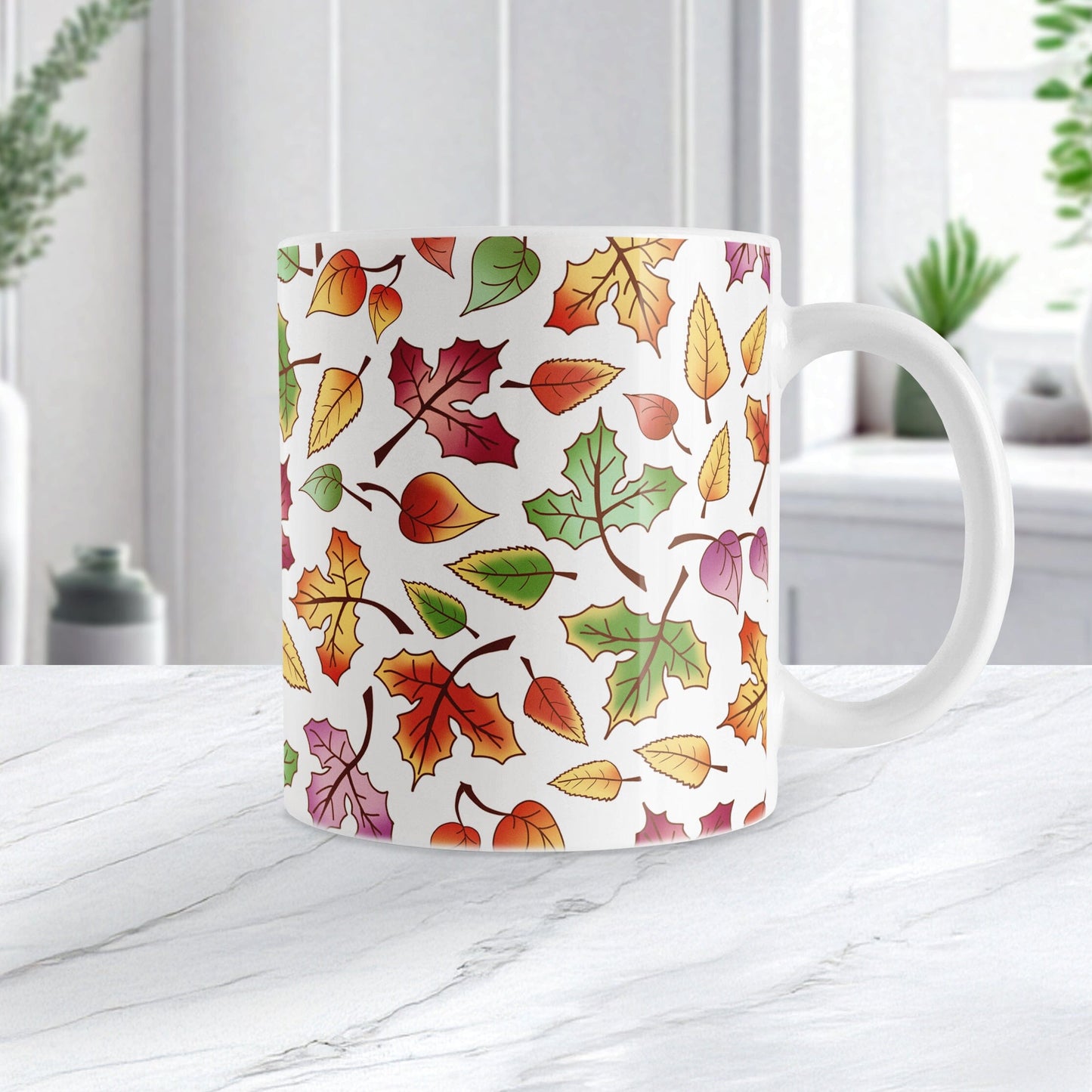 Mug with autumn leaf pattern on a white marble surface