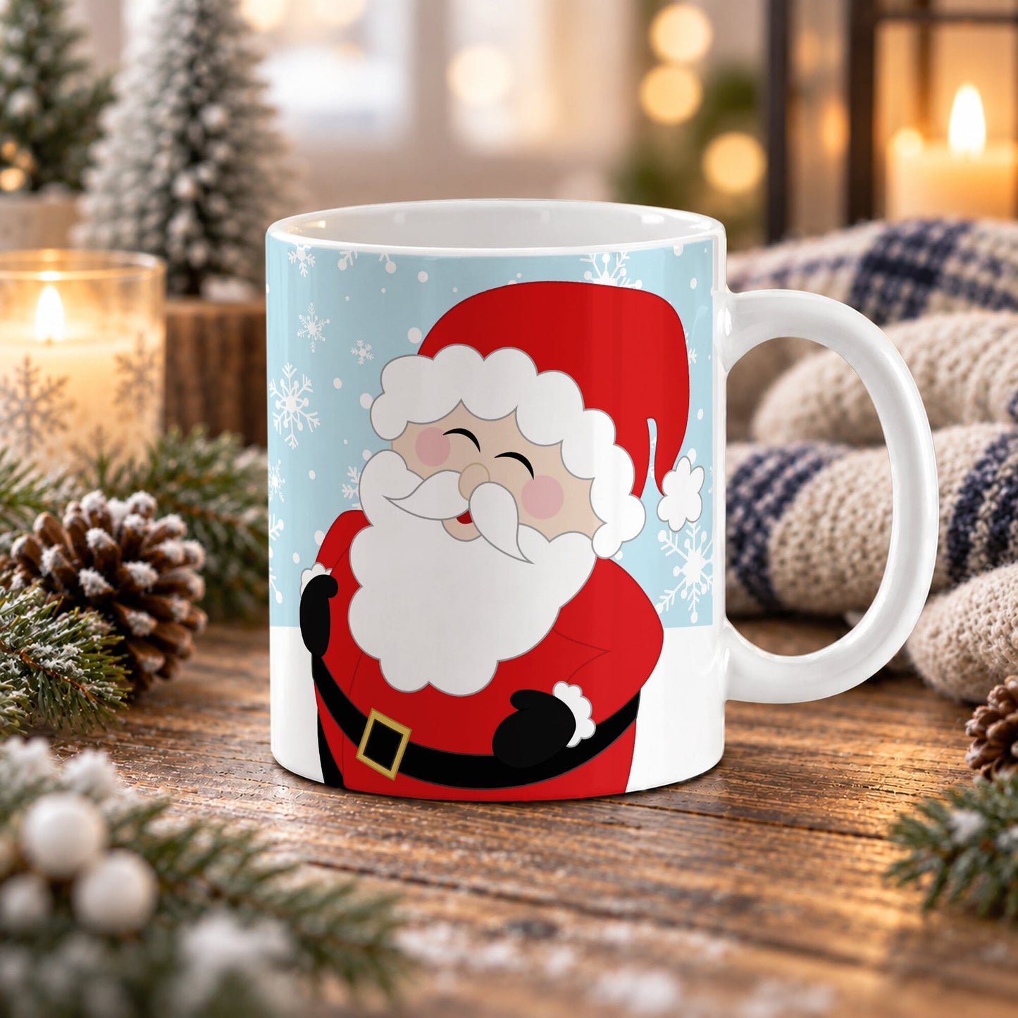 An 11 oz white ceramic mug featuring a cartoon illustration of Santa Claus on a light blue winter background, styled on a wooden table with holiday decorations like pinecones, evergreen branches, and a knitted blanket.