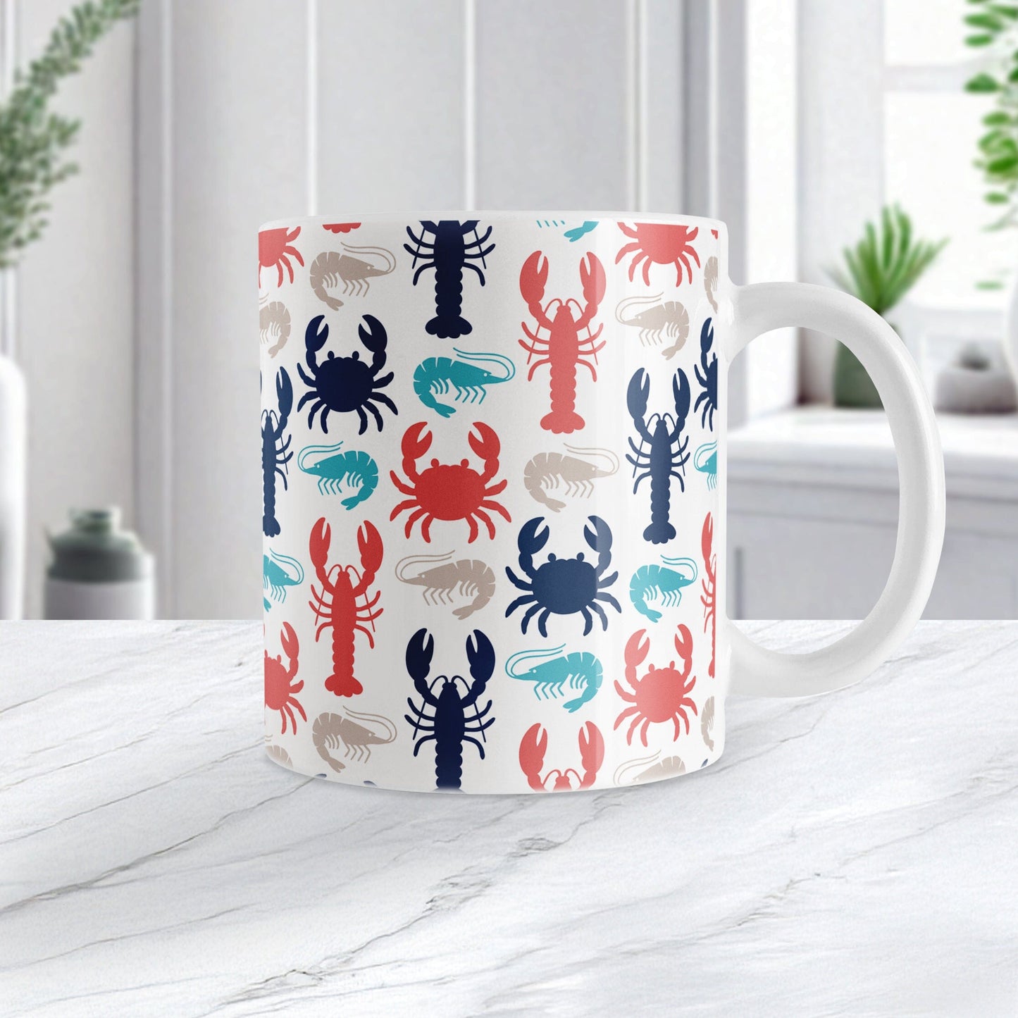 Coastal Crustaceans Mug (11oz) at Amy's Coffee Mugs. A ceramic coffee mug with crabs, lobsters, and shrimp, in colors of ocean navy, coral red, sand beige, and teal, in a pattern that wraps around the mug up to the handle. Image shows the mug on a white marble countertop.