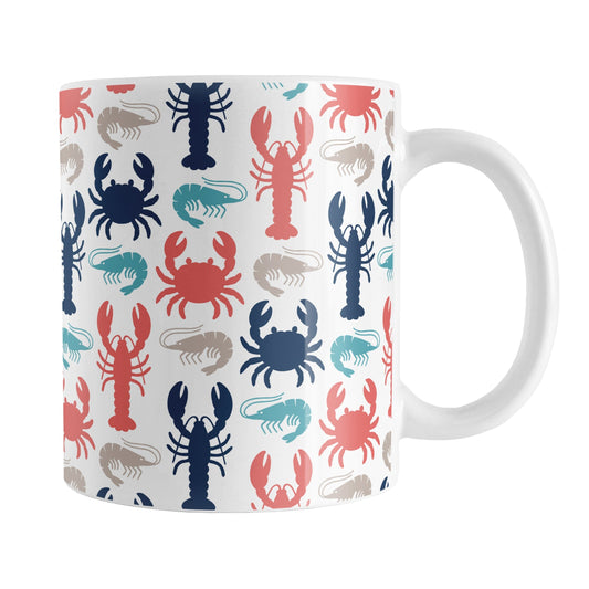 Coastal Crustaceans Mug (11oz) at Amy's Coffee Mugs. A ceramic coffee mug with crabs, lobsters, and shrimp, in colors of ocean navy, coral red, sand beige, and teal, in a pattern that wraps around the mug up to the handle.