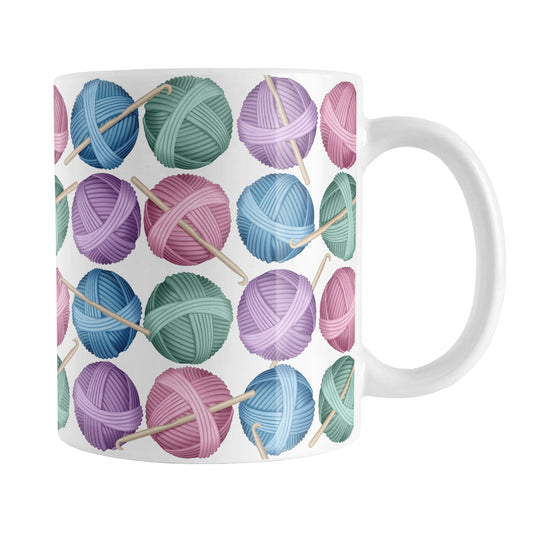 Crochet Yarn Pattern Mug (11oz) at Amy's Coffee Mugs. A ceramic coffee mug designed with colorful balls of yarn in blue, pink, purple, and mint green with crochet hooks in a pattern that wraps around the mug up to the handle.