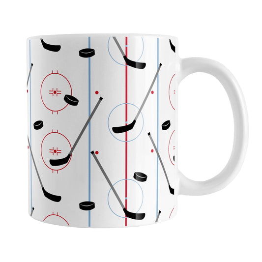 Hockey Rink Pattern Mug (11oz) at Amy's Coffee Mugs. A ceramic coffee mug designed with hockey rink red and blue lines, coupled with hockey sticks and hockey pucks, a pattern that wraps around the mug up to the handle.
