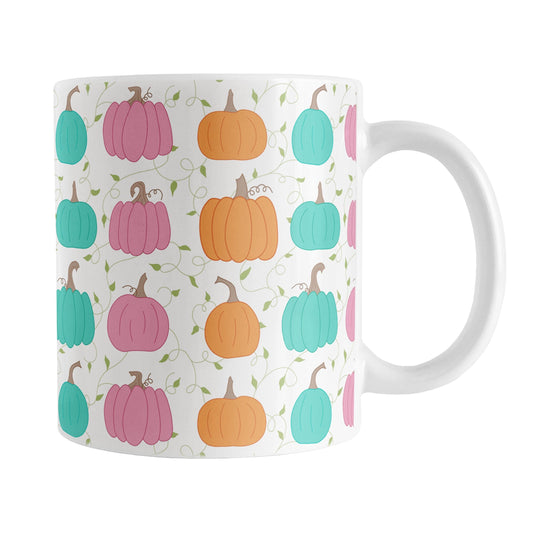 11 oz orange teal pink pumpkin mug with colorful pumpkins, delicate green vines, and leaves on a white background.