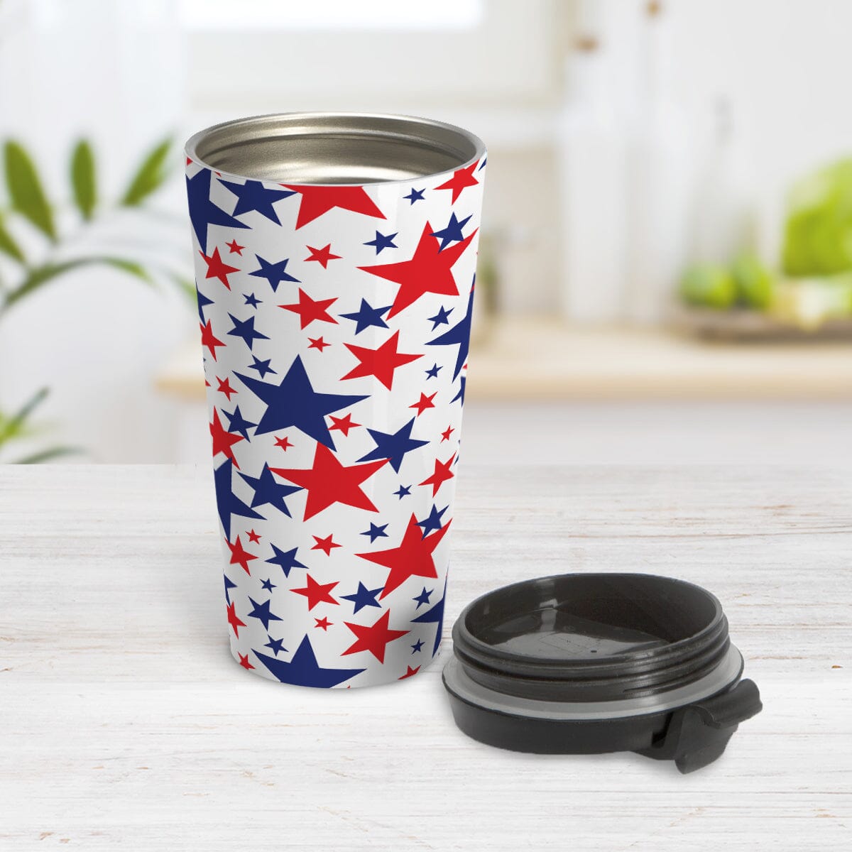 Patriotic Stars Travel Mug (15oz) at Amy's Coffee Mugs. A stainless steel travel mug for the 4th for July (Independence Day) designed with red and blue stars, in varying sizes, over a white background in a pattern that wraps around the mug. Image shows the mug open with the lid beside it.