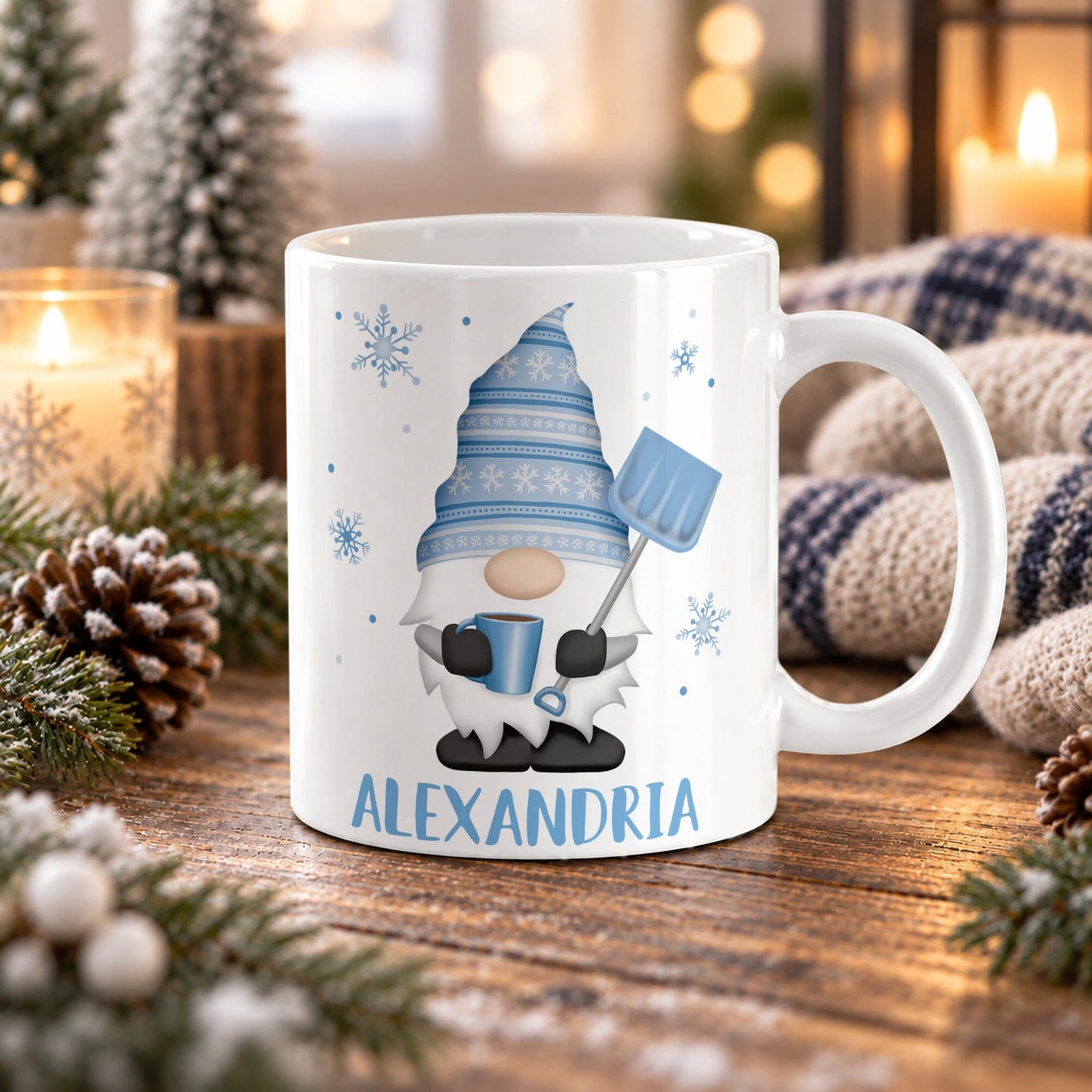 11 oz personalized winter gnome mug with blue snowflake hat, blue mug, snow shovel, blue snowflakes, and custom name printed below, displayed on a wooden table with cozy winter decor around it.