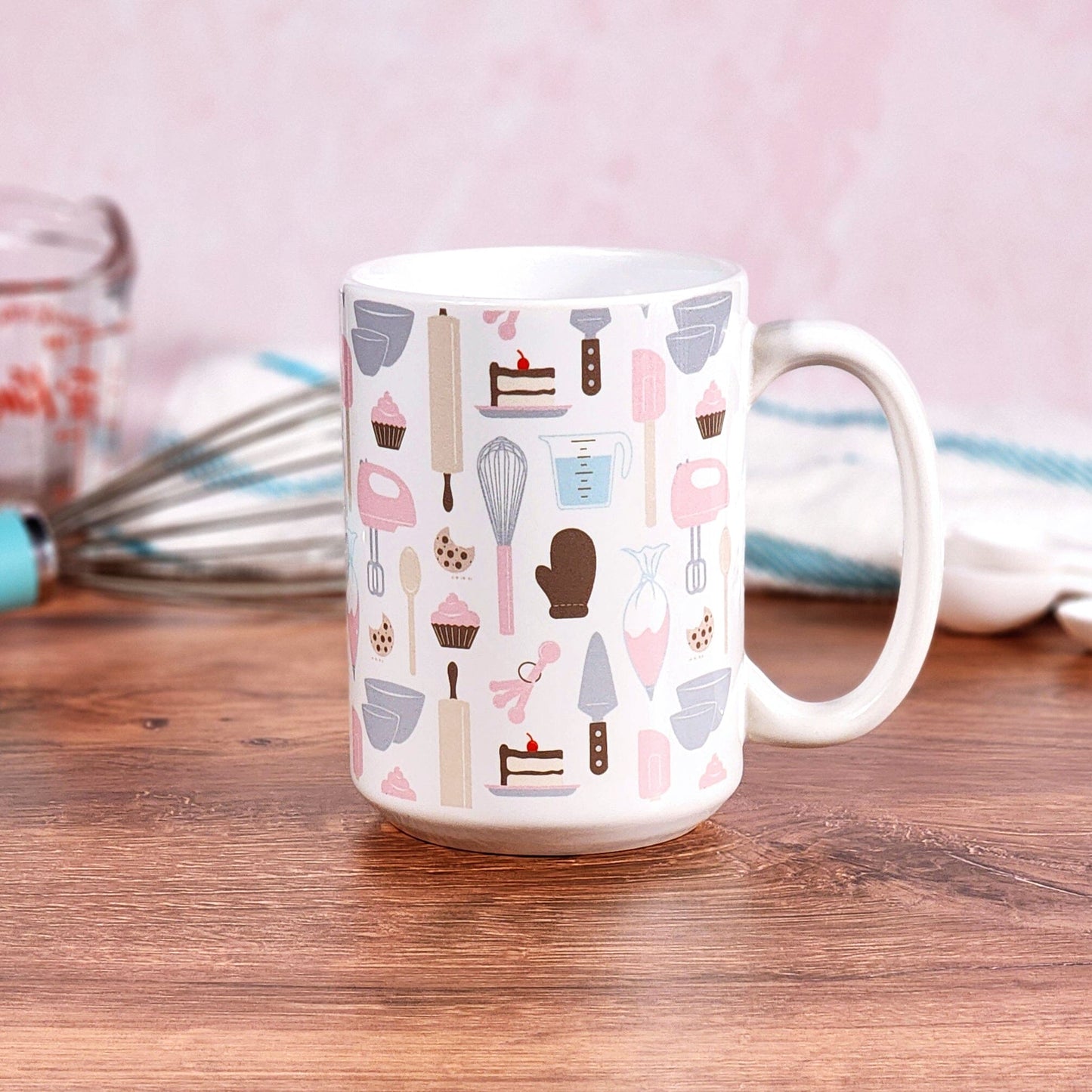 Pink Baking Pattern Mug (15oz) from Amy's Coffee Mugs on a table with baking supplies.