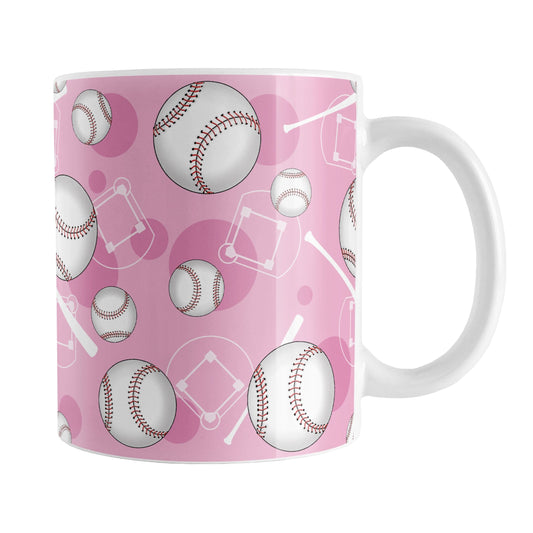Pink Baseball Pattern Mug (11oz) at Amy's Coffee Mugs. A ceramic coffee mug designed with a pattern of baseballs, baseball diamonds, baseball bats, and pink circles over a light pink background color that wraps around the mug up to the handle.