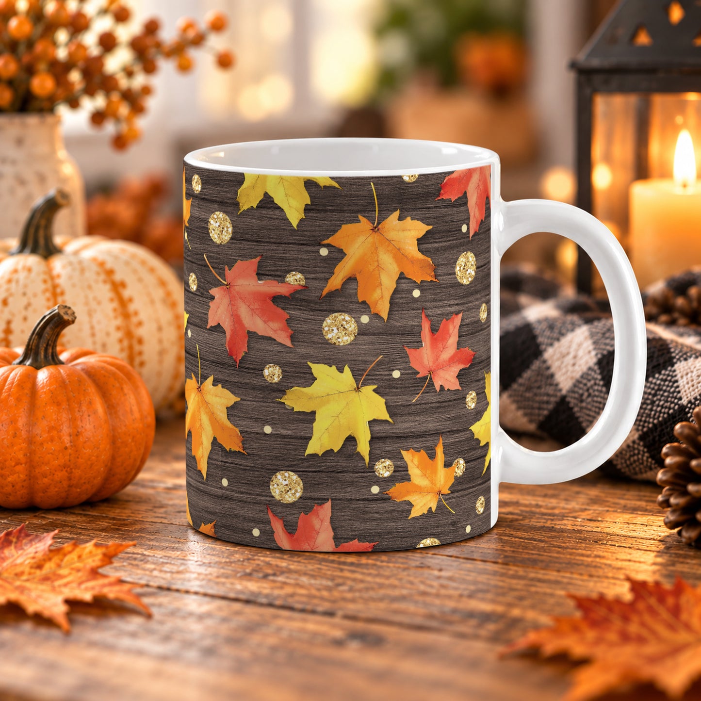 11 oz rustic fall leaves mug with orange, red, and yellow maple leaves and gold-colored glitter-illustrated circles over a dark brown wood-look background. The mug is on a wooden table with fall decor around it.