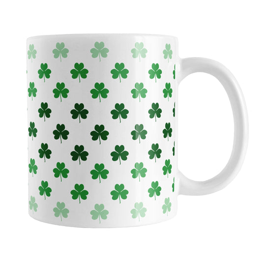 Shamrocks in Green Mug (11oz) at Amy's Coffee Mugs. A ceramic coffee mug designed with shamrocks (or clovers) in different shades of green, with the darker green color across the middle and the lighter green along the top and bottom, in a pattern that wraps around the mug to the handle.