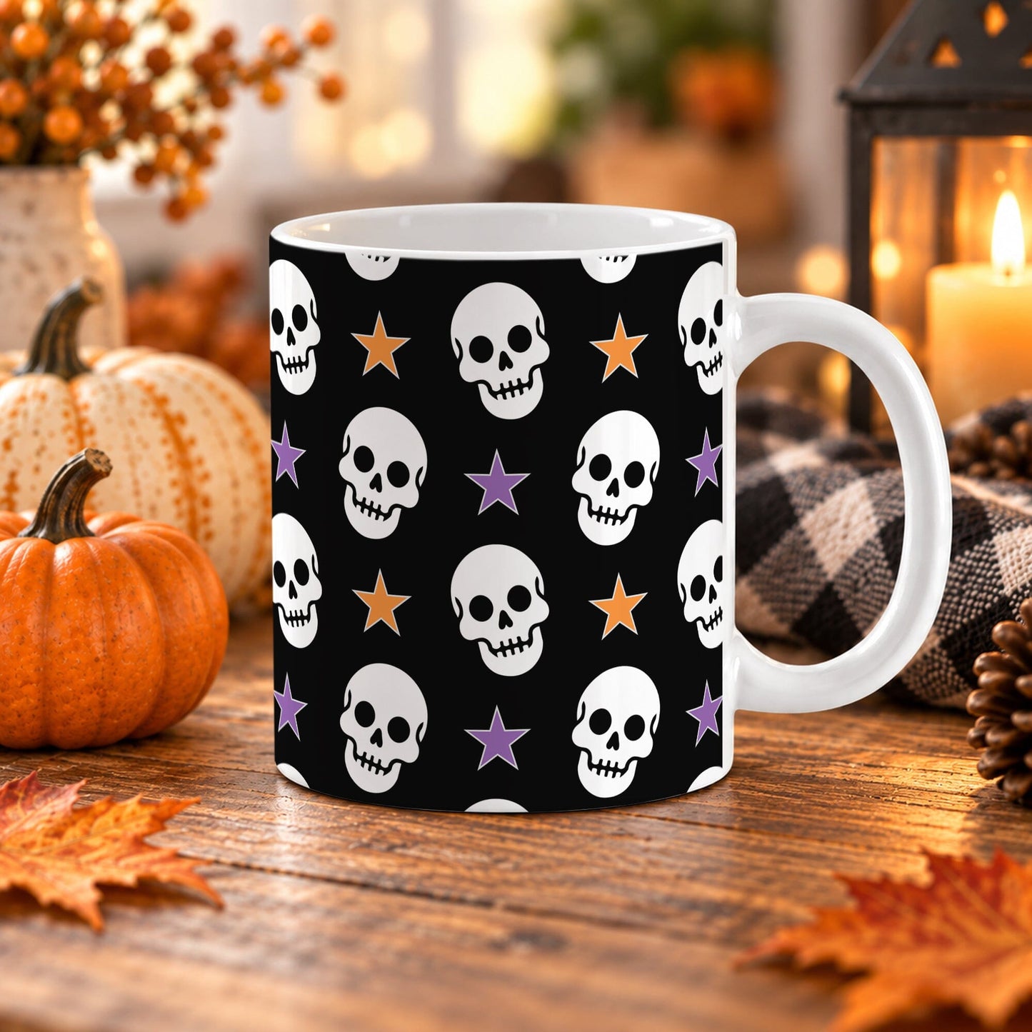 White 11 oz ceramic Halloween mug with repeating white skulls and orange and purple stars on a black background, shown on a wooden table with fall decor.