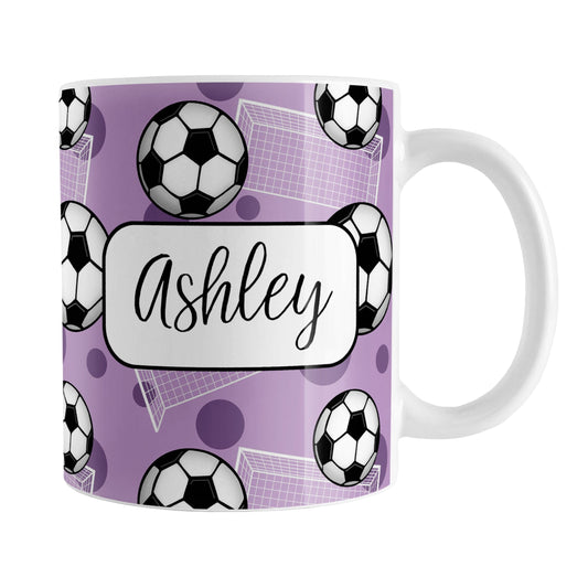 Soccer Ball and Goal Personalized Purple Soccer Mug (11oz) at Amy's Coffee Mugs. A ceramic coffee mug designed with a pattern of soccer balls and white soccer goals over a purple background with purple circles. Your personalized name is custom-printed in a fun black script font on both sides of the mug over the soccer pattern.