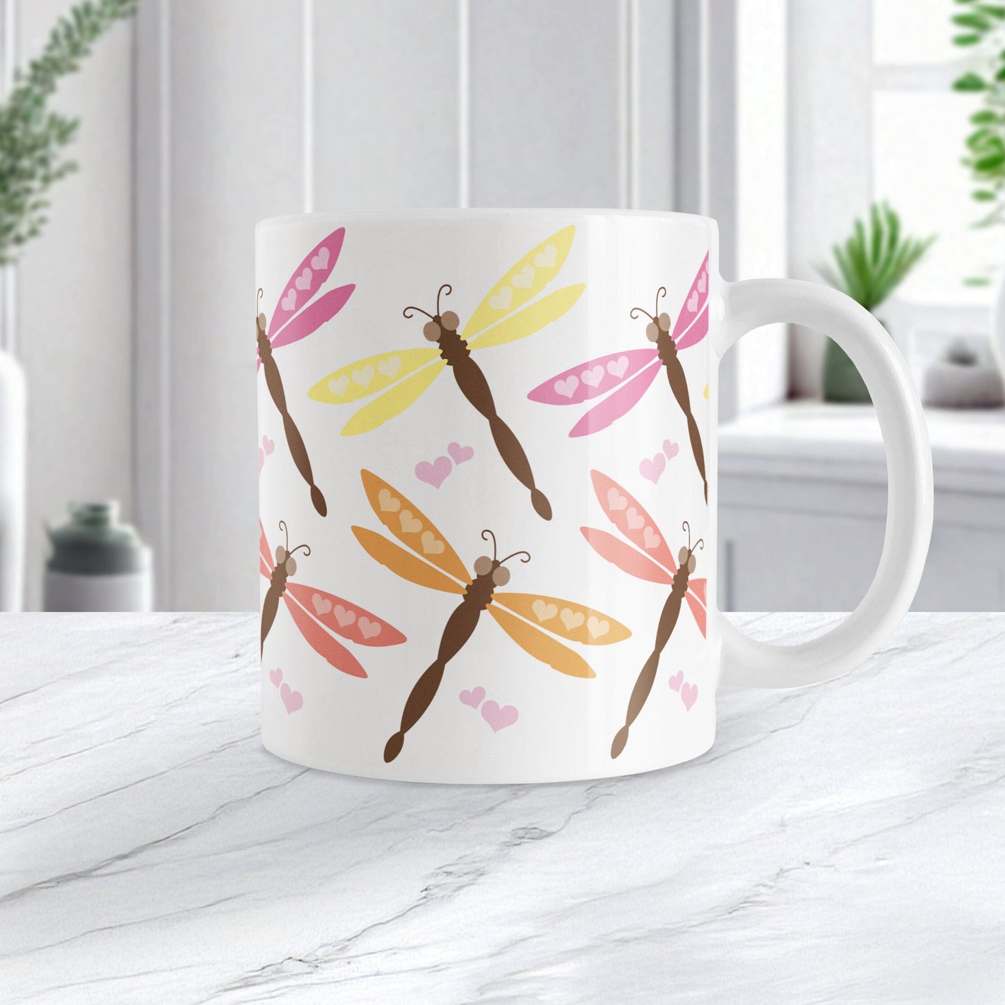White mug with colorful dragonfly pattern on a marble surface