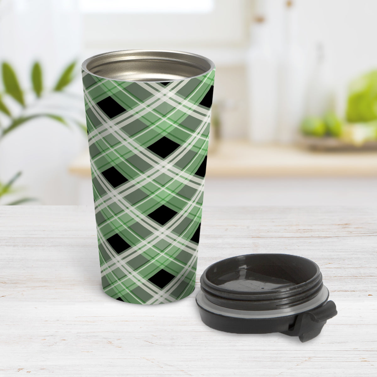 Alternative Green Plaid Travel Mug (15oz) at Amy's Coffee Mugs. A stainless steel travel mug designed with a diagonal green, black, and white plaid pattern that wraps around the mug. Designed for someone who likes plaid patterns and loves the color green. Photo shows the mug open with the lid on the table beside it.