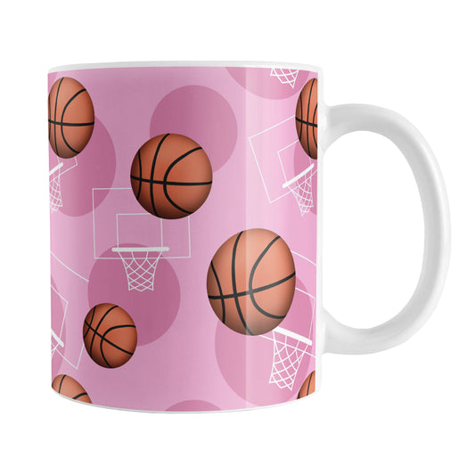 Basketball Themed Pattern - Pink Basketball Mug (11oz) at Amy's Coffee Mugs. A ceramic coffee mug designed with a sports themed pattern with basketballs and white hoops/nets over a pink colored background that wraps around the mug up to the handle.