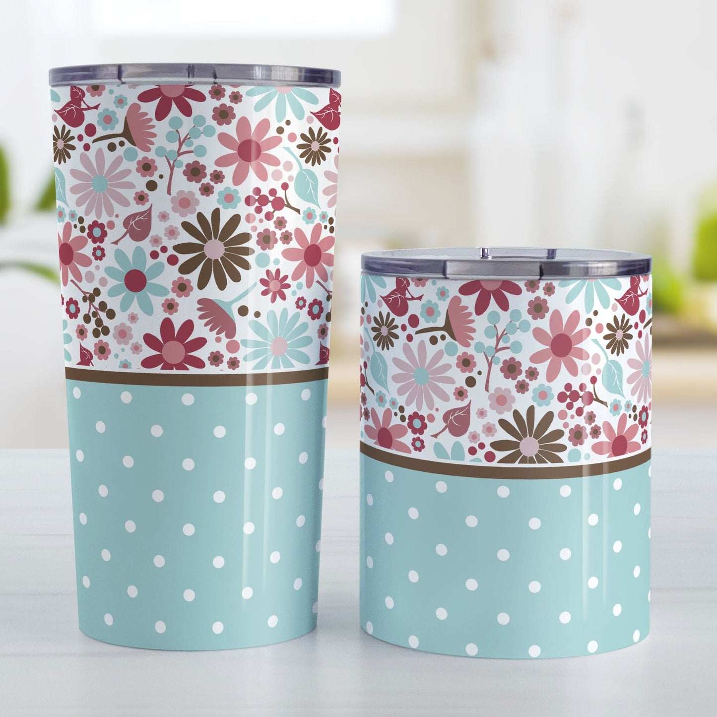 Berry Blue Summer Flowers Polka Dot Tumbler Cups (20oz or 10oz) at Amy's Coffee Mugs. Stainless steel tumbler cups designed with a pretty floral pattern in a gorgeous berry pink color palette with light blue and brown along the top, and a light blue polka dot pattern along the bottom. These patterns wrap around the cups. Photo shows both sized cups on a table next to each other.