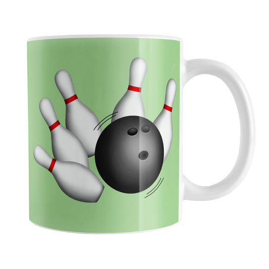 Bowling Ball and Pins Green Bowling Mug (11oz) at Amy's Coffee Mugs. A ceramic coffee mug designed with an illustration of a bowling ball striking bowling pins on both sides of the mug over a green background color that wraps around the mug up to the handle.