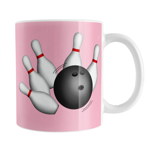 Bowling Ball and Pins Pink Bowling Mug (11oz) at Amy's Coffee Mugs. A ceramic coffee mug designed with an illustration of a bowling ball striking bowling pins on both sides of the mug over a pink background color that wraps around the mug up to the handle.
