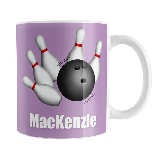 Personalized Bowling Ball and Pins Purple Mug (11oz) at Amy's Coffee Mugs. A ceramic coffee mug designed with an illustration of a bowling ball striking bowling pins on both sides of the mug over a purple background color that wraps around the mug up to the handle. Your personalized name is custom printed in white below the bowling ball and pins.