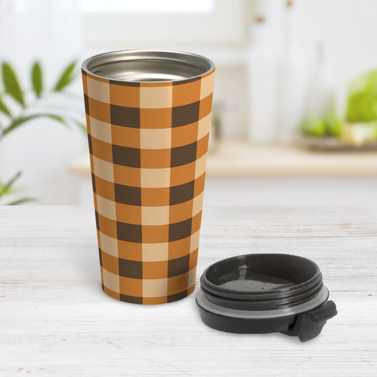 Brown and Orange Fall Buffalo Plaid Travel Mug at Amy's Coffee Mugs. A travel mug designed with a fall-inspired buffalo plaid (buffalo check) pattern in brown, orange, and beige. This pattern wraps around the mug. Photo shows the mug on a table with its lid beside it.