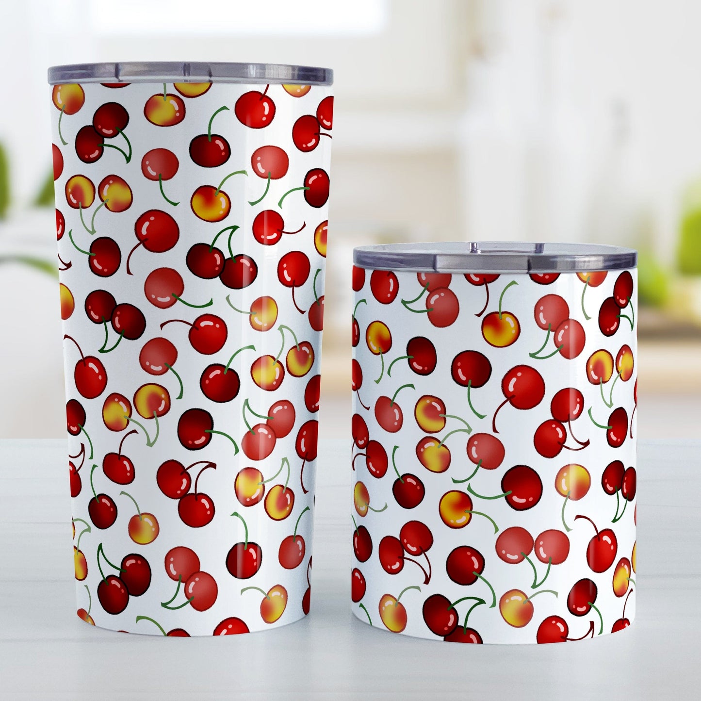 Cherries Tumbler Cups (20oz or 10oz) at Amy's Coffee Mugs. Stainless steel tumbler cups designed with different types of cherries in a pattern that wraps around the cups. Photo shows both sized cups next to each other.