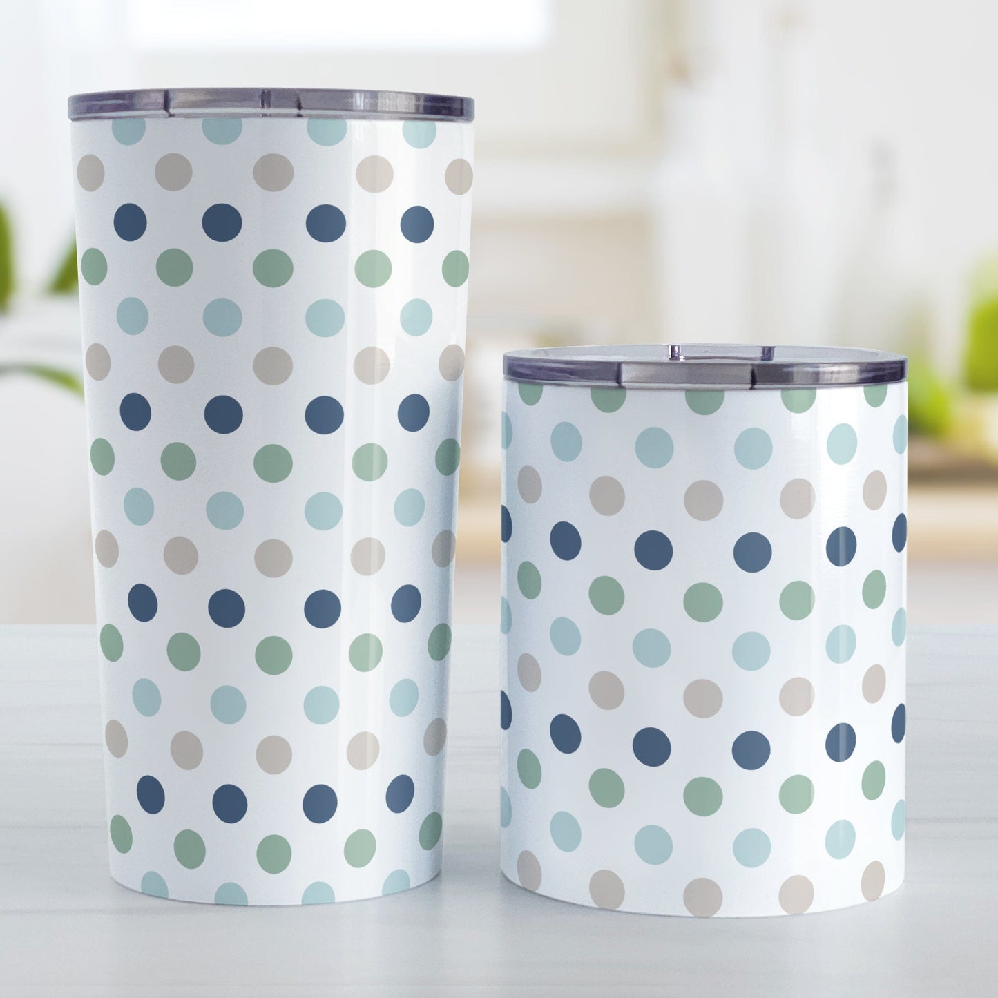 Coastal Polka Dots Tumbler Cups (20oz of 10oz) at Amy's Coffee Mugs. Stainless steel tumbler cups designed with a pattern of polka dots in a coastal color scheme that wraps around the cups. Photo shows both sized cups on a table next to each other.