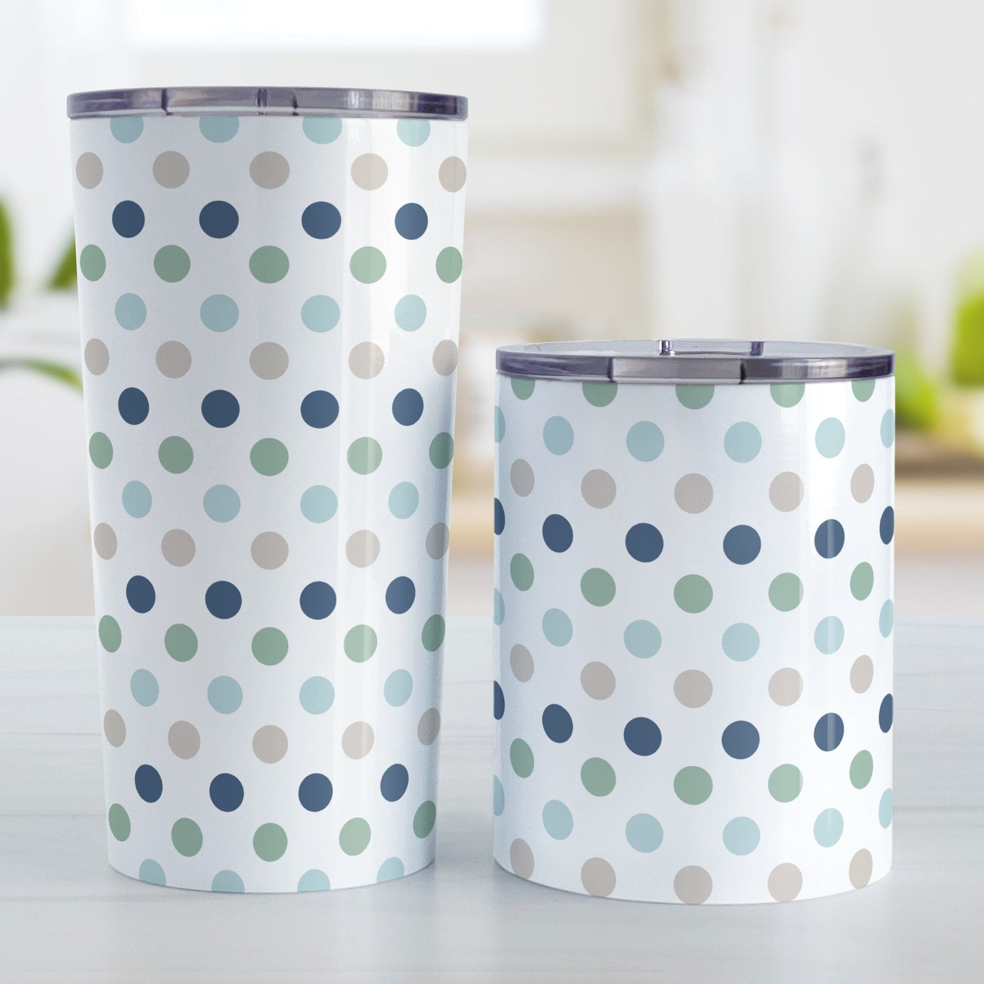 Coastal Polka Dots Tumbler Cups (20oz of 10oz) at Amy's Coffee Mugs. Stainless steel tumbler cups designed with a pattern of polka dots in a coastal color scheme that wraps around the cups. Photo shows both sized cups on a table next to each other.