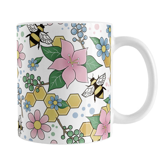 Colorful Pink Floral Bee Pattern Mug (11oz) at Amy's Coffee Mugs. A ceramic coffee mug designed with pink, blue, and green flowers and leaves with bees and golden yellow honeycomb pieces in a pattern that wraps around the mug up to the handle.