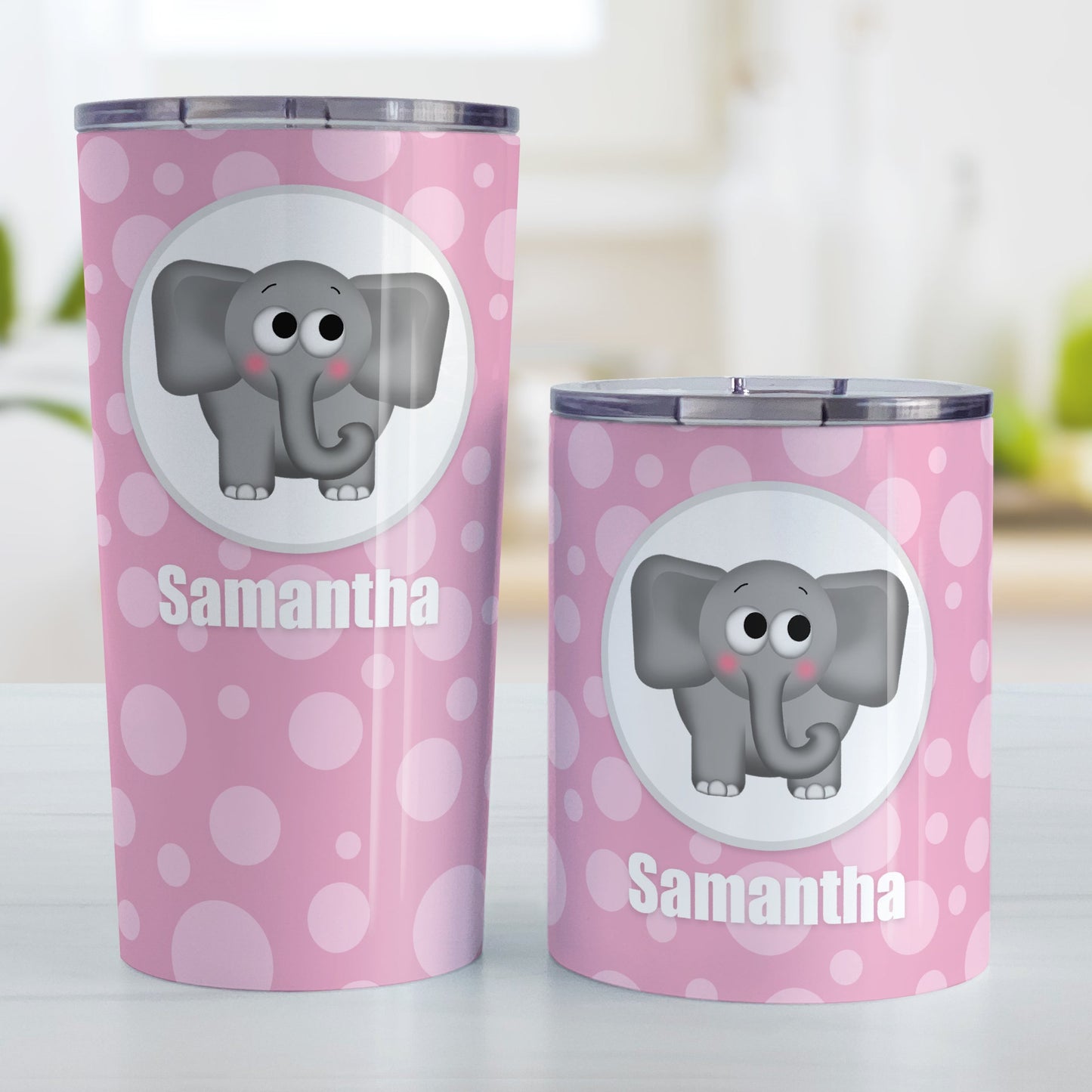 Cute Elephant Bubbly Pink Personalized Tumbler Cup (20oz and 10oz, stainless steel insulated) at Amy's Coffee Mugs. A tumbler cup designed with an adorable and affectionate gray elephant in a white circle outlined in gray over a pink bubbly background that wraps around the cup. Your name is personalized in white below the cute elephant. Photo shows both sized cups on a table next to each other.