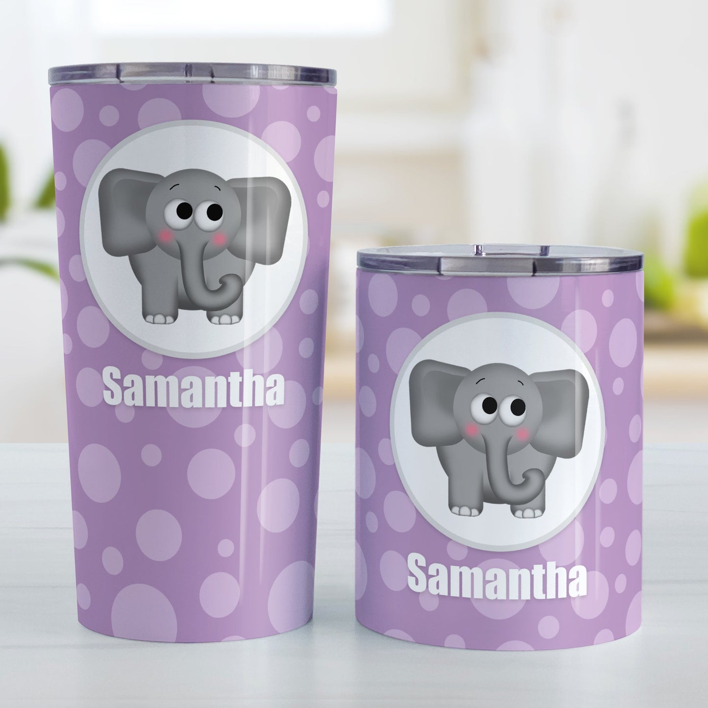 Cute Elephant Bubbly Purple Personalized Tumbler Cup (20oz and 10oz, stainless steel insulated) at Amy's Coffee Mugs. A tumbler cup designed with an adorable and affectionate gray elephant in a white circle outlined in gray over a purple bubbly background that wraps around the cup. Your name is personalized in white below the cute elephant. Photo shows both sized cups on a table next to each other.