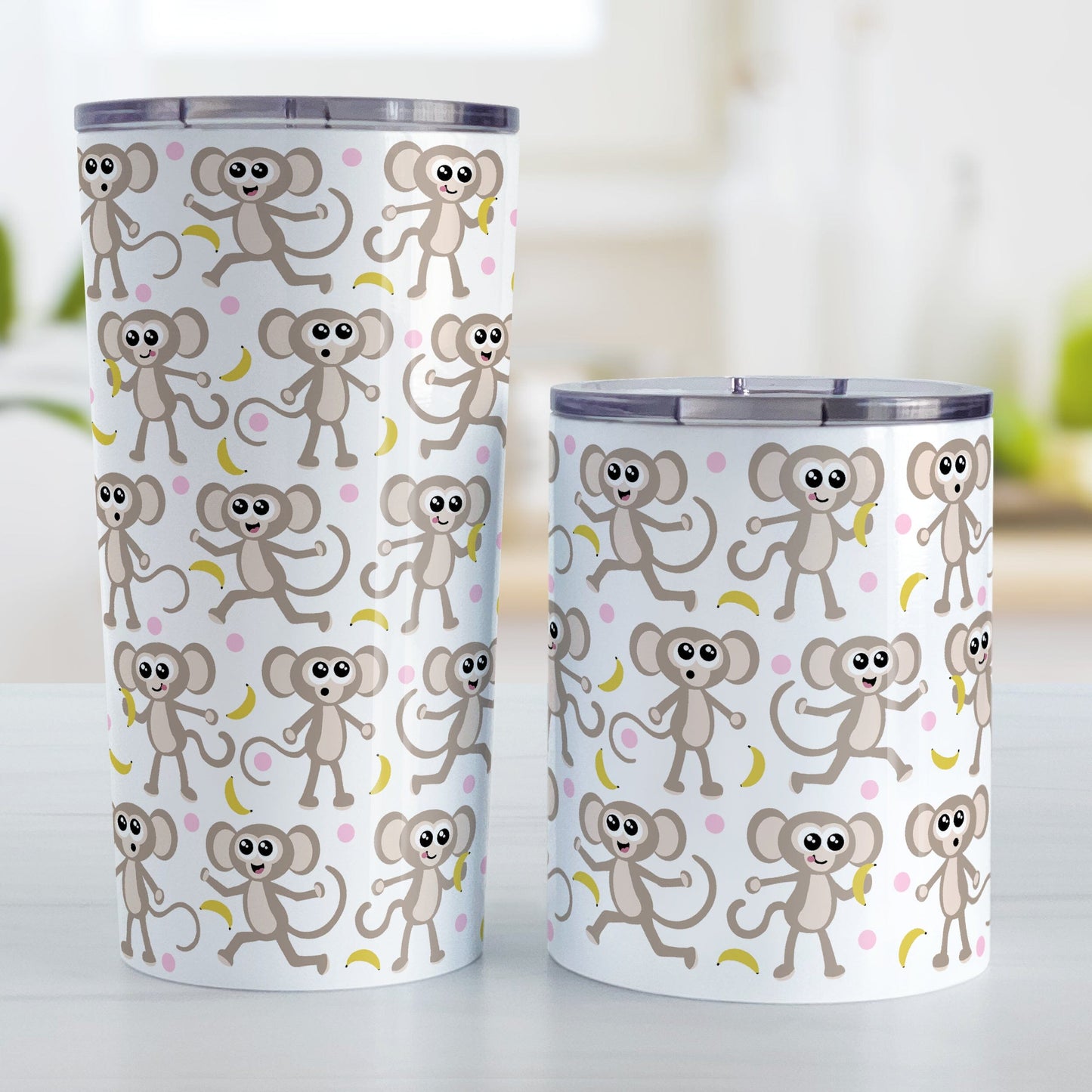 Cute Monkey Pattern with Pink Dots Tumbler Cup (20oz or 10oz) at Amy's Coffee Mugs. Stainless steel tumbler cups designed with an adorable pattern of monkeys having fun, complete with bananas and pink dots around them, that wraps around the cups. Photo shows both size cups on a table next to each other.