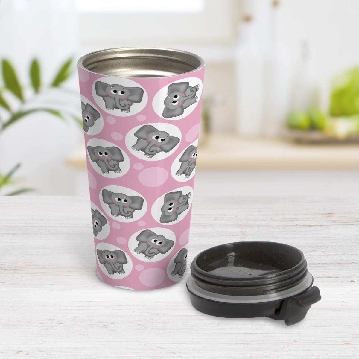 Cute Pink Elephant Pattern Travel Mug (15oz) at Amy's Coffee Mugs. A travel mug designed with cute and affectionate gray elephants in white circles scattered over a pink background color in a pattern that wraps around the travel mug. Photo shows the mug open on a table with its lid beside it.