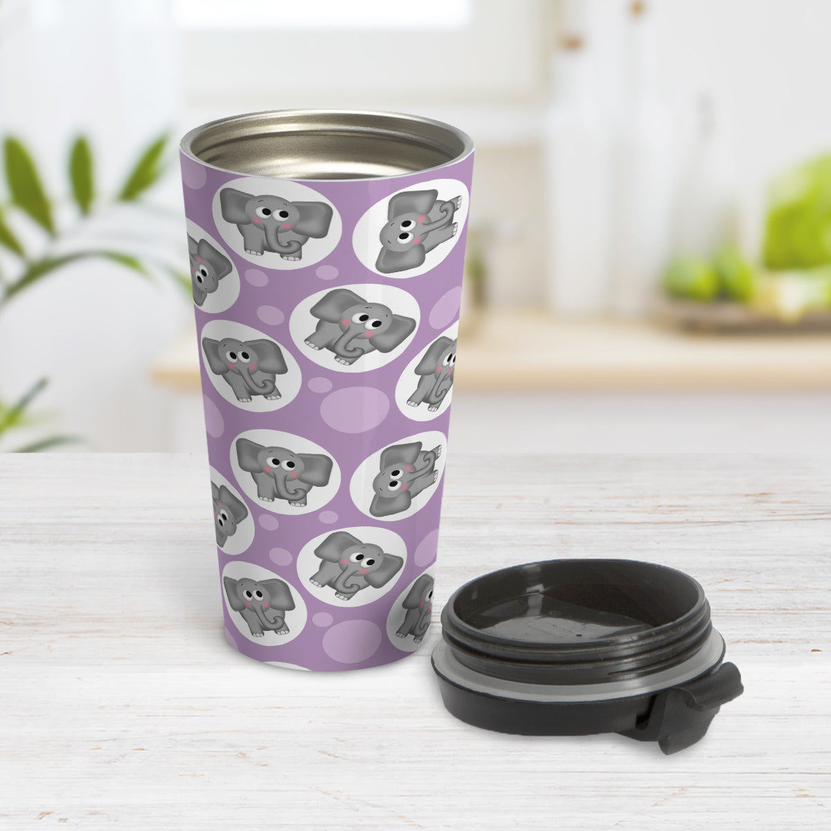 Cute Purple Elephant Pattern Travel Mug (15oz) at Amy's Coffee Mugs. A travel mug designed with cute and affectionate gray elephants in white circles scattered over a purple background color in a pattern that wraps around the travel mug. Photo shows the mug open on a table with the lid next to it.