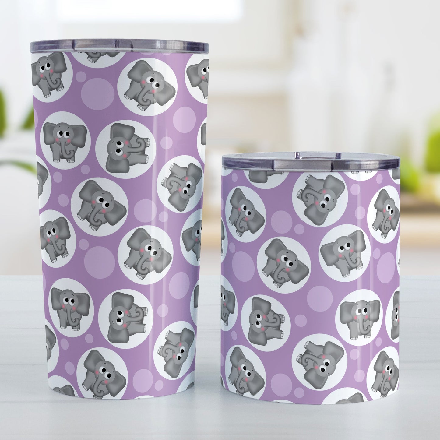 Cute Purple Elephant Pattern Tumbler Cup (20oz and 10oz, stainless steel insulated) at Amy's Coffee Mugs. Tumbler cups designed with cute and affectionate gray elephants in white circles scattered over a purple background color in a pattern that wraps around the cups. Photo shows both sized cups on a table next to each other.
