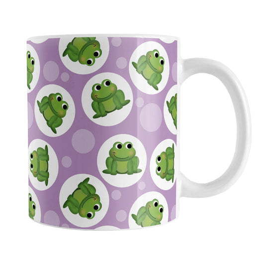 Cute Purple Frog Pattern Mug (11oz) at Amy's Coffee Mugs. A ceramic coffee mug designed with cute and smiling green frogs in white circles scattered over a purple background color in a pattern that wraps around the mug up to the handle.