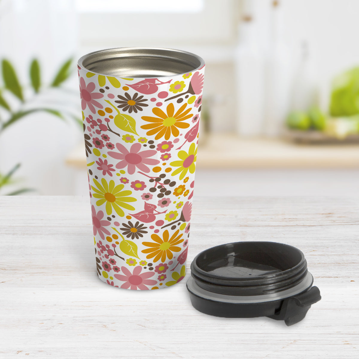Fruity Summer Flowers Travel Mug (15oz) at Amy's Coffee Mugs. A travel mug designed with pretty fruity-colored flowers and leaves with berry pink, orange, yellow, and brown colors in a floral pattern that wraps around the travel mug. Photo shows the mug open on a table with its lid beside it.