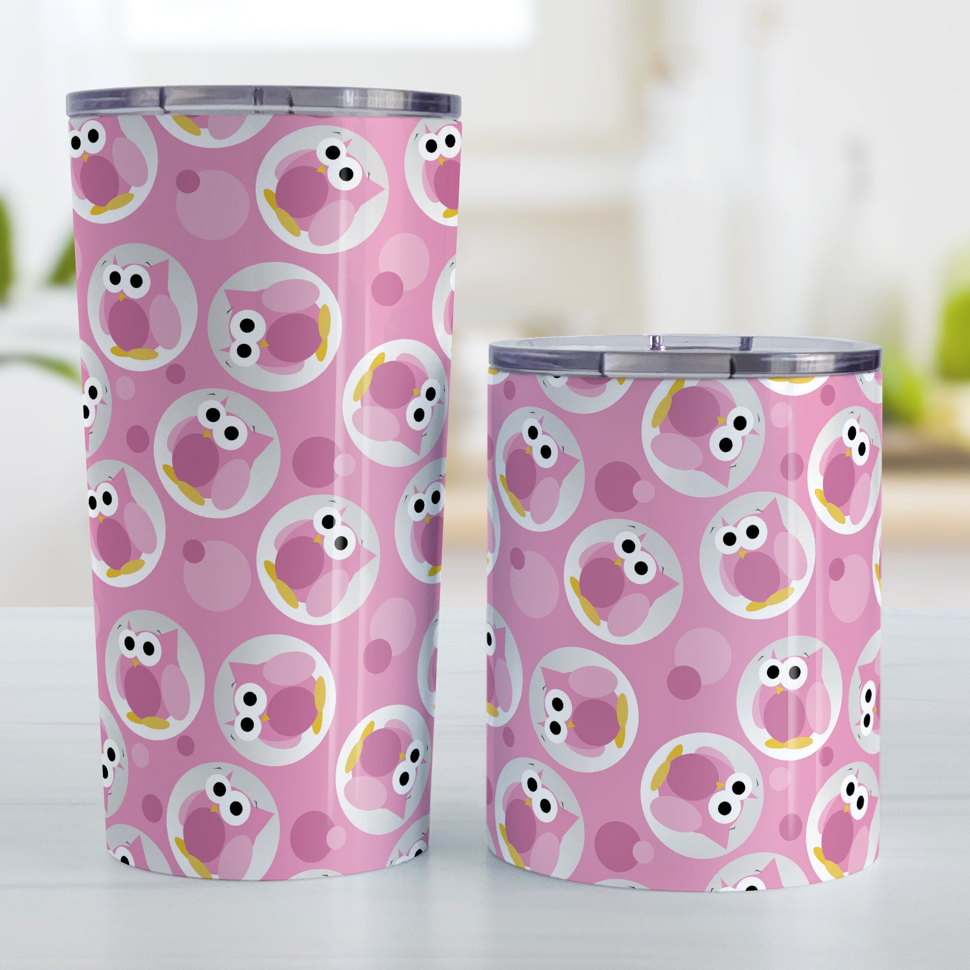 Funny Cute Pink Owl Pattern Tumbler Cup (20oz and 10oz, stainless steel insulated) at Amy's Coffee Mugs. A tumbler cup designed with a pattern of funny and cute pink owls in a light gray circles scattered over a pink background color that wraps around the cup. Photo shows both sized cups on a table next to each other.