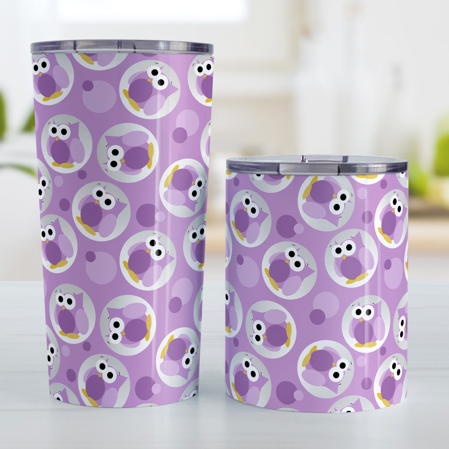 Funny Cute Purple Owl Pattern Tumbler Cup (20oz and 10oz, stainless steel insulated) at Amy's Coffee Mugs. A tumbler cup designed with a pattern of funny and cute purple owls in a light gray circles scattered over a purple background color that wraps around the cup. Photo shows both sized cups on a table next to each other.
