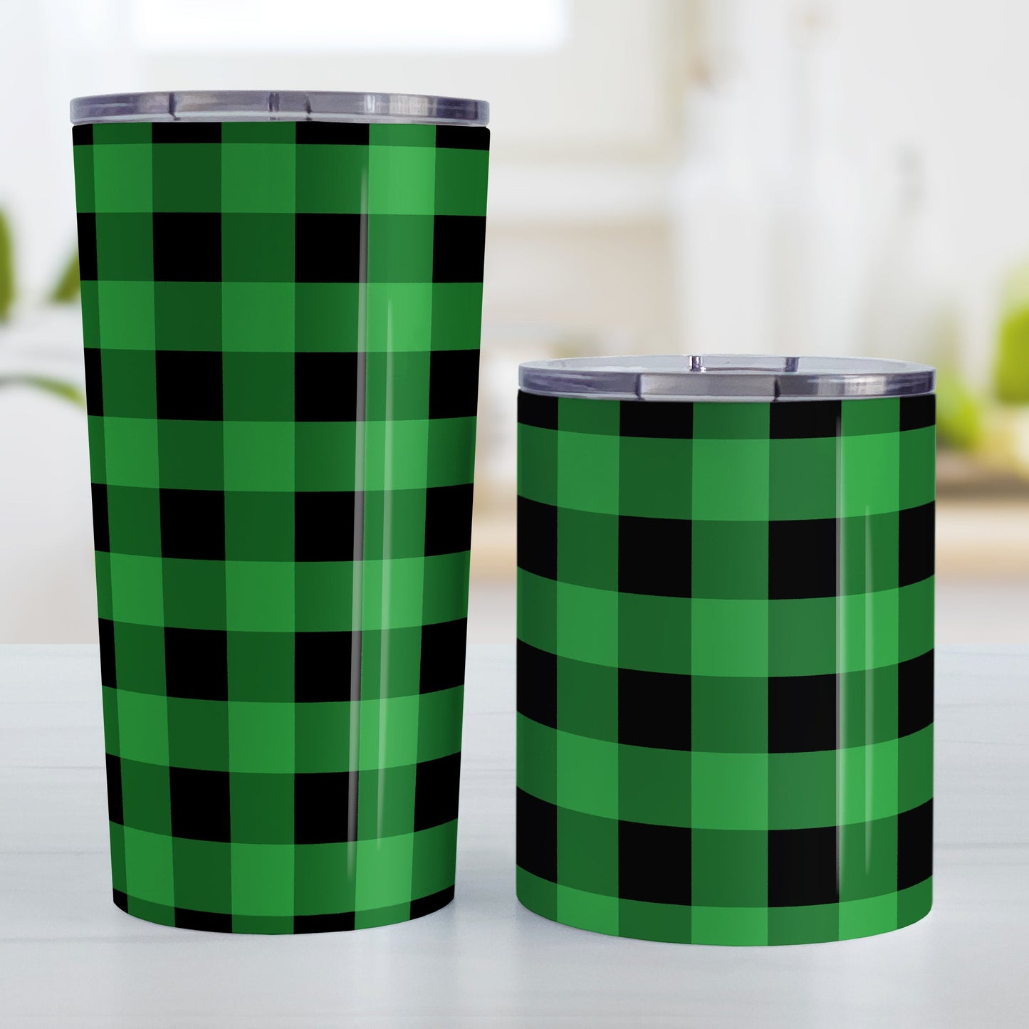 Green and Black Buffalo Plaid Tumbler Cup (20oz and 10oz, stainless steel insulated) at Amy's Coffee Mugs. A tumbler cup designed with a black and green buffalo plaid (buffalo check) pattern that wraps around the cup. Photo shows both sized cups on a table next to each other.