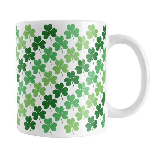 Green Clovers Mug (11oz) at Amy's Coffee Mugs. A ceramic coffee mug designed with a pattern of clovers (shamrocks) in three different shades of green that wraps around the mug up to the handle.