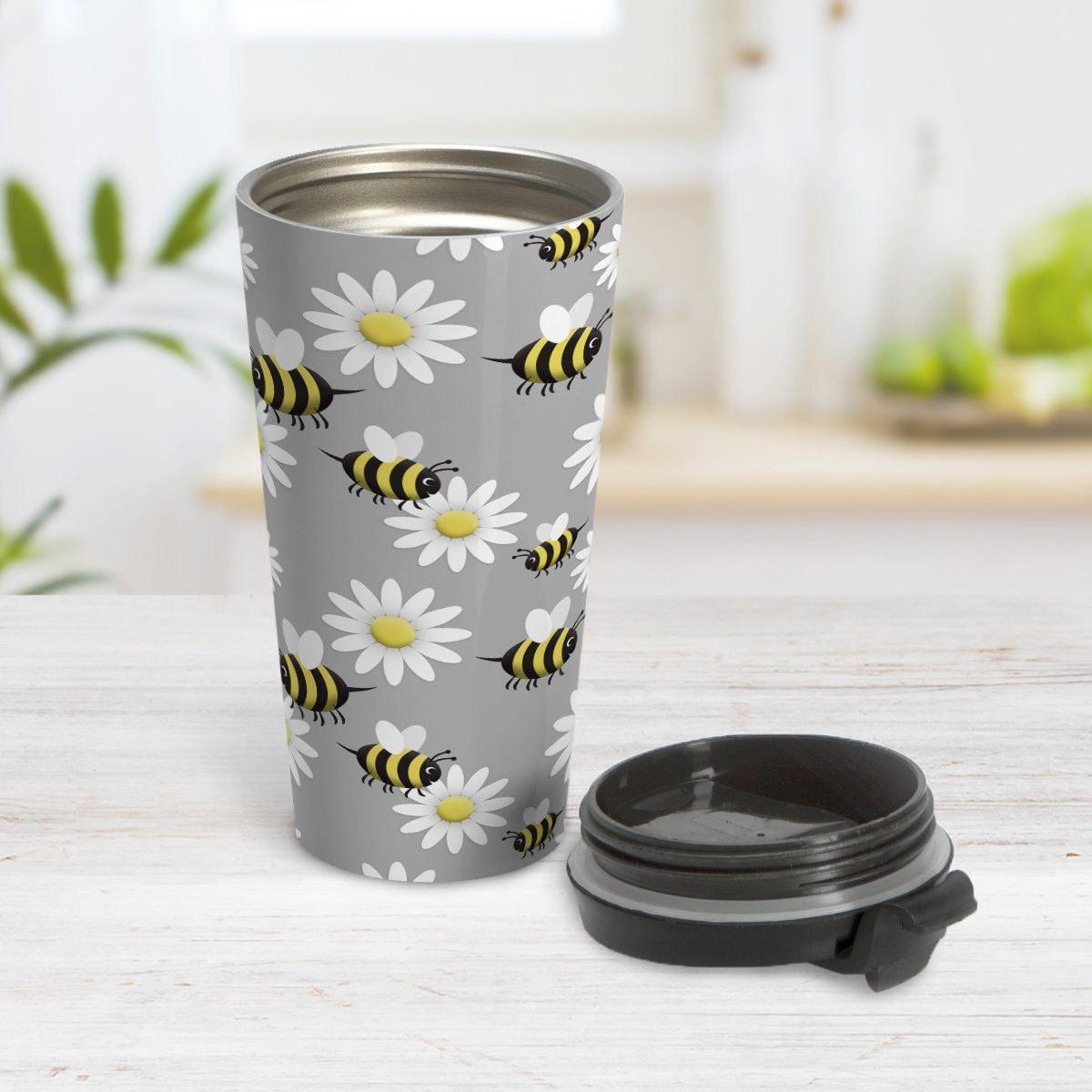 Happy Bee and Daisy Pattern Travel Mug at Amy's Coffee Mugs. A travel mug designed with a cute pattern of happy bees and white daily flowers over a light gray background color that wraps around the mug. Photo shows the mug open on a table with its lid beside it.