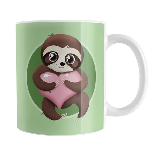 Happy Sloth Pink Heart Green Mug (11oz) at Amy's Coffee Mugs. A ceramic coffee mug designed with an adorable and happy brown sloth holding a pink heart in a green circle on both sides of the mug over a lighter green background that wraps around the mug up to the handle.