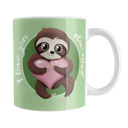 I Love You Slow Much Cute Sloth Mug (11oz) at Amy's Coffee Mugs. A ceramic coffee mug designed with an adorable and happy brown sloth holding a pink heart in a green circle on both sides of the mug over a lighter green background that wraps around the mug up to the handle. The words "I love you slow much" are printed in a white font around the sloth.