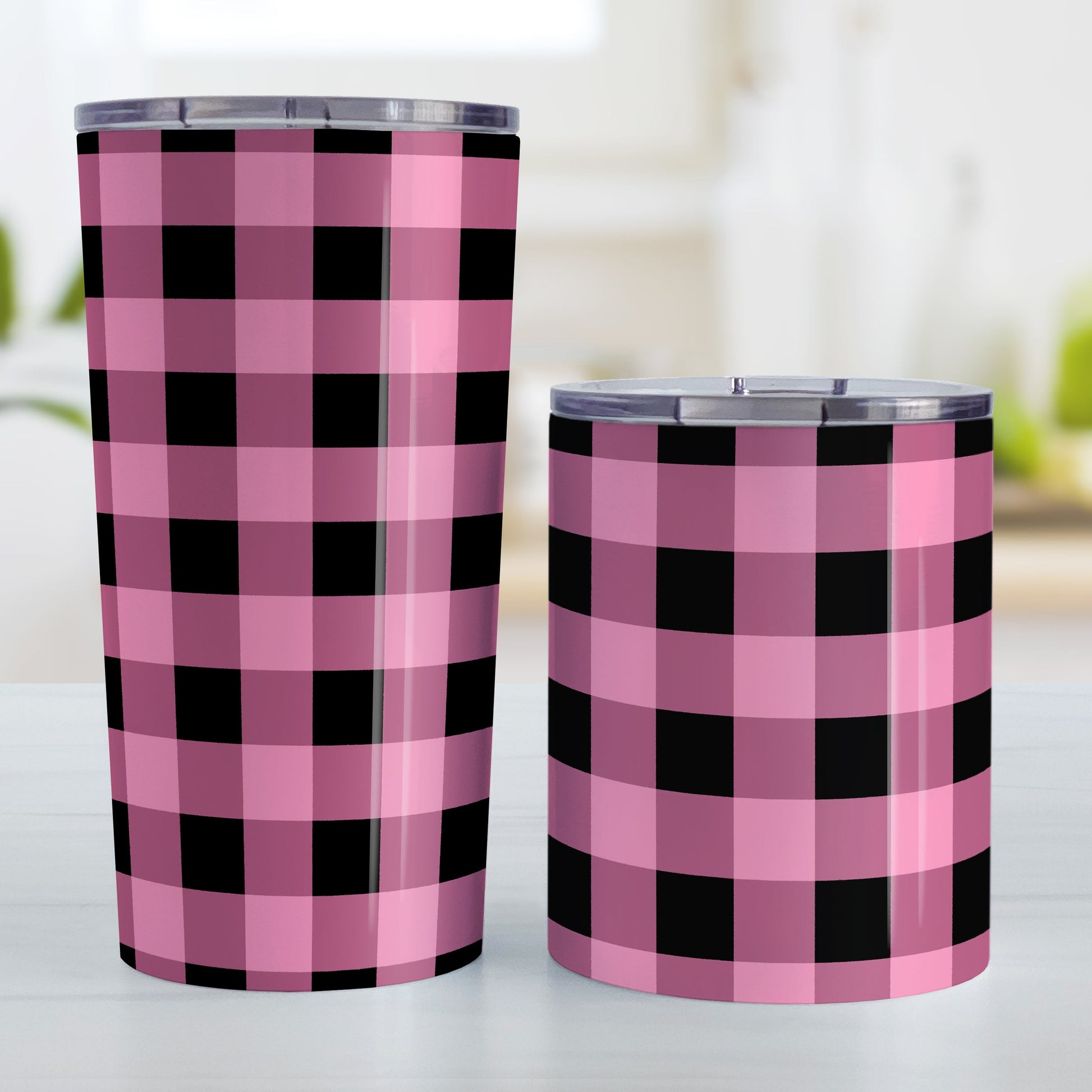 Light Pink and Black Buffalo Plaid Tumbler Cup (20oz and 10oz, stainless steel insulated) at Amy's Coffee Mugs. A tumbler cup designed with a black and light pink buffalo plaid (buffalo check) pattern that wraps around the cup. Photo shows both sized cups on a table next to each other.