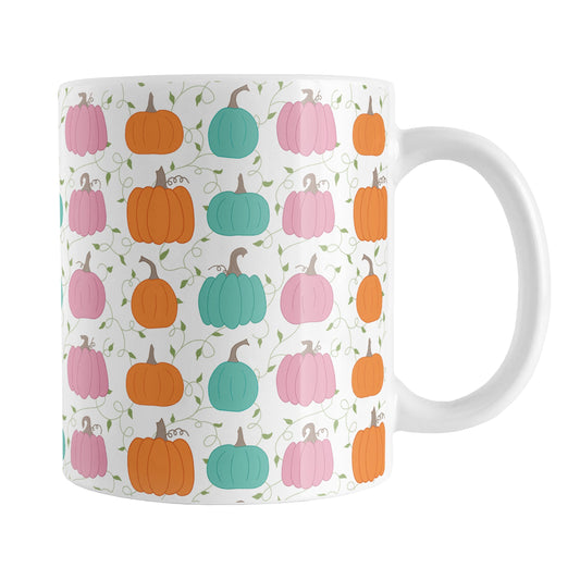 Orange Teal Pink Pumpkin Pattern Mug (11oz) at Amy's Coffee Mugs. A ceramic coffee mug designed with a pattern of orange, teal, and pink pumpkins over a green vine and leaves pattern on a white background that wraps around the mug up to the handle.