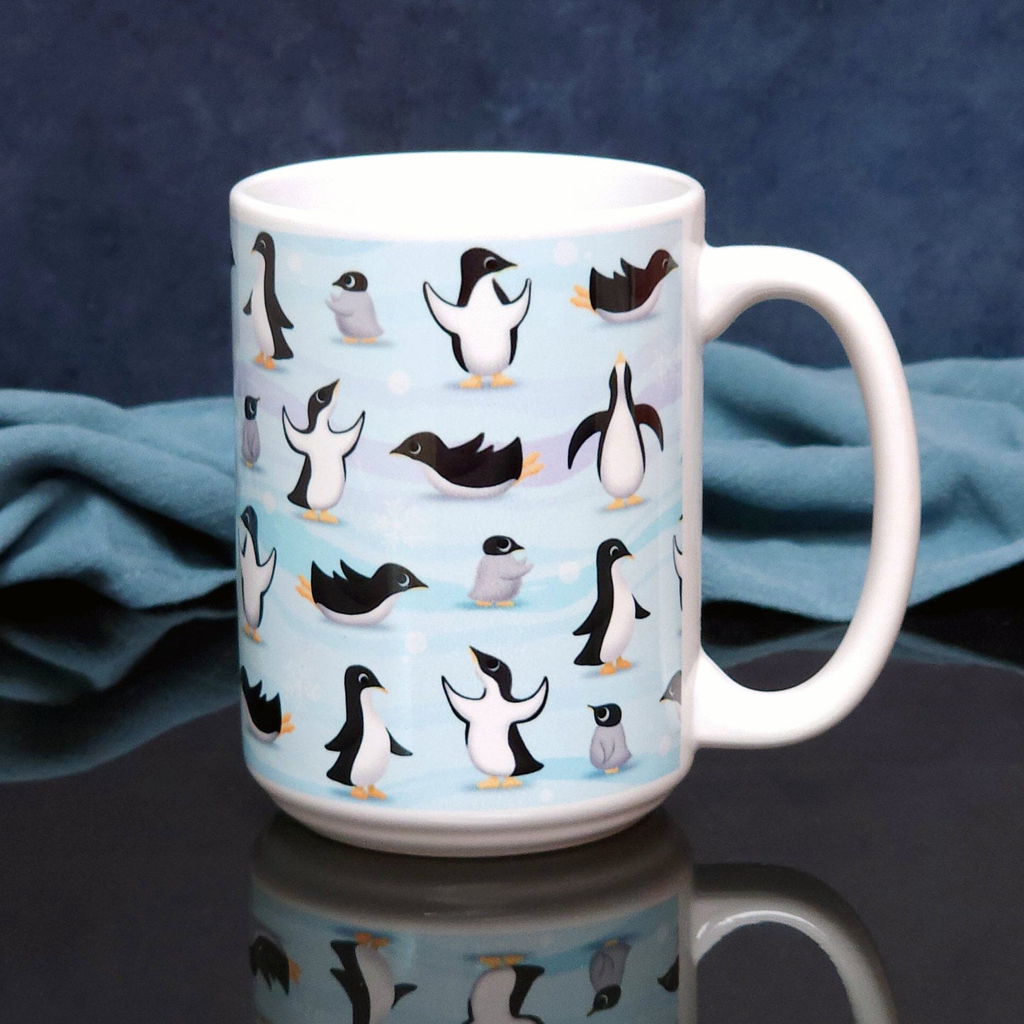 Penguin Parade Pattern Mug (15oz) on a glossy black tabletop with a midnight blue background.. A ceramic coffee mug designed with a fun penguin parade pattern featuring a variety of penguins and baby penguins over an Antarctic background with waves of blue, turquoise, and purple colors with hints of snowflakes that wraps around the mug.