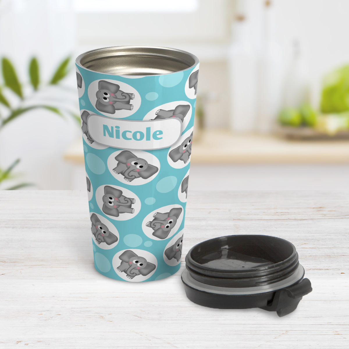 Personalized Cute Turquoise Elephant Pattern Travel Mug (15oz) at Amy's Coffee Mugs. A travel mug designed with cute and affectionate gray elephants in white circles scattered over a turquoise background color in a pattern that wraps around the travel mug. Your name is custom printed in turquoise on white positioned over the elephant pattern. Photo shows the mug open on a table with it's lid beside it.