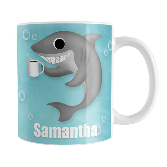 Personalized Cute Underwater Coffee Shark Mug (11oz) at Amy's Coffee Mugs. A ceramic coffee mug designed with an under the sea illustration of a cute shark smiling and holding a cup of coffee on both sides of the mug over a turquoise underwater background with bubbles that wraps around the mug up to the handle. Your personalized name is displayed in white below the adorable and happy shark.