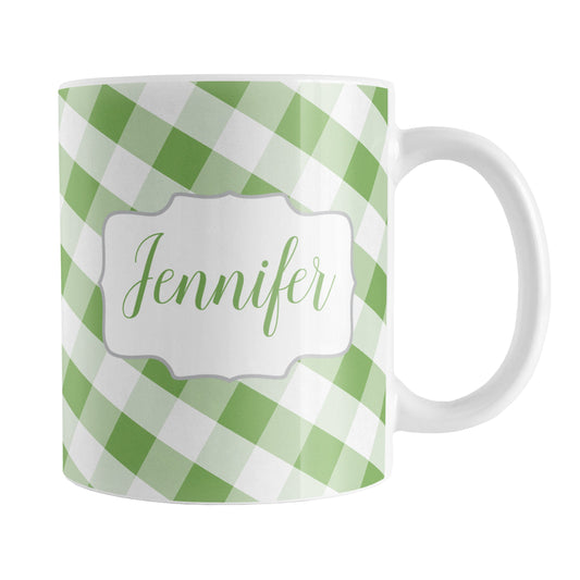 Personalized Green Gingham Mug (11oz) at Amy's Coffee Mugs. A ceramic coffee mug designed with a slanted green and white gingham pattern that wraps around the mug up to the handle. Your personalized name is custom-printed in a green script font on both sides of the mug over the gingham pattern.